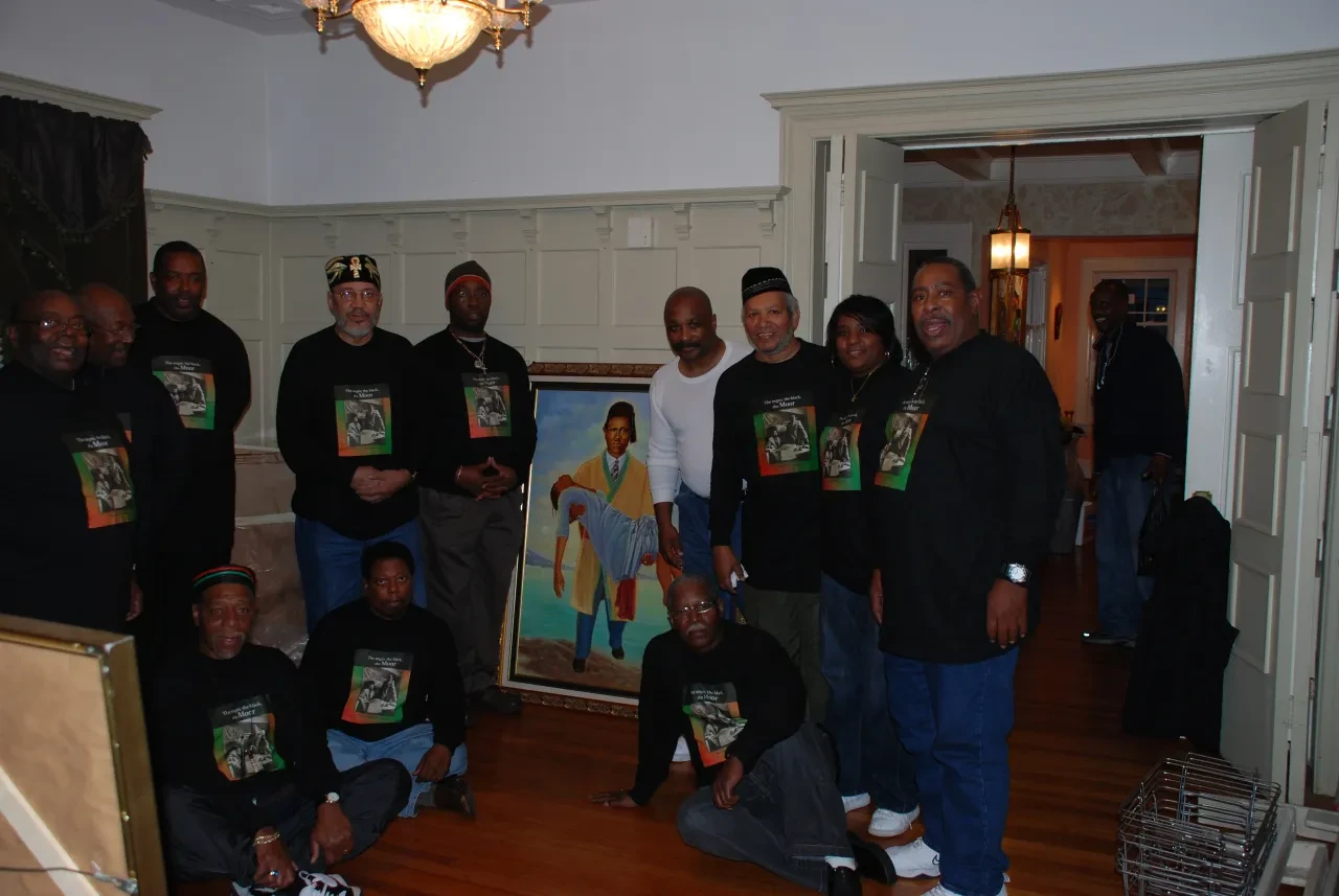 Community group assembled beside a framed portrait