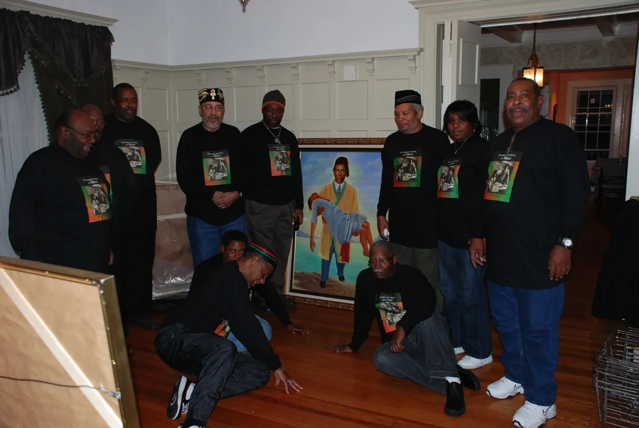 Community group beside a framed portrait